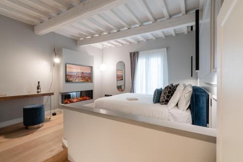 a white bedroom with a bed and a fireplace at Maison Ginori Guelfa in Florence