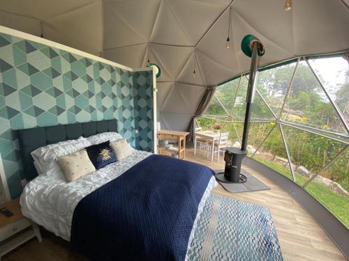 um quarto com uma cama numa tenda em Benllech Glamping em Benllech