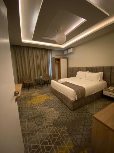 a hotel room with a bed and a table at فندق جولدن توليب أبها - GOLDEN TULIP ABHA HOTEl in Abha