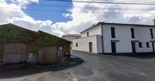 a white building with ivy growing on the side of it at Du vignoble à l'Atlantique - Résidence Montifault gîtes du 2 au 3 pièces in Le Pallet