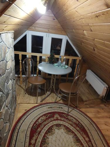 ein Zimmer mit einem Tisch und Stühlen in einer Hütte in der Unterkunft Садиба Маковиця in Jaremtsche