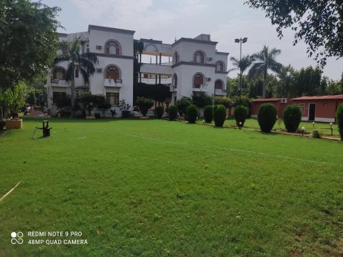 a large lawn in front of a large building at Hotel Sanctuary Resort in Sawāi Mādhopur