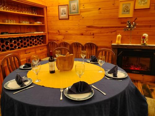 a table in a wine cellar with a yellow tablecloth and wine glasses at Hotel Capellan in Navia
