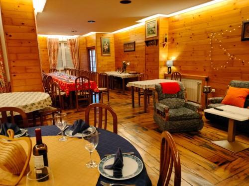 un restaurante con paredes de madera, mesas y sillas en Hotel Capellan, en Navia