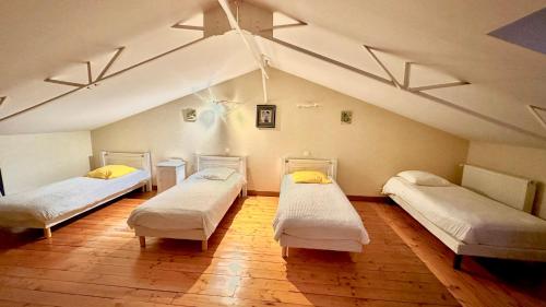 Cette chambre mansardée comprend 3 lits. dans l'établissement Gîte rural Le Péché Mignon, à Lignol-le-Château