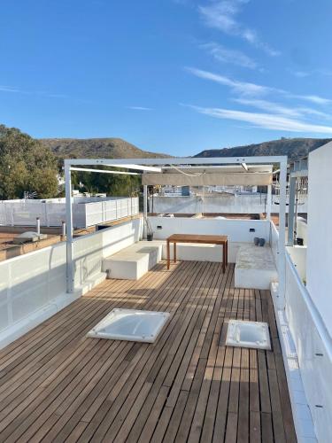 a deck with a table and benches on a ship at Duplex con terraza en Agua Amarga in Agua Amarga