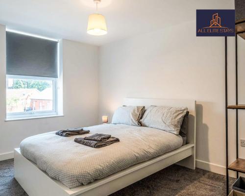 Un dormitorio blanco con una cama con toallas. en Swan House Apartment 9 - 2 Bed Apartment - Sleeps 6 - Free Parking - Liverpool - close to city centre - By ALL ELITE STAYS en Liverpool