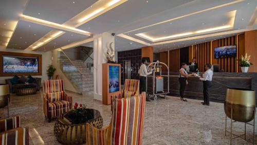 a lobby with people standing at a counter in a hotel at Oak Plaza Hotels East Airport in Accra