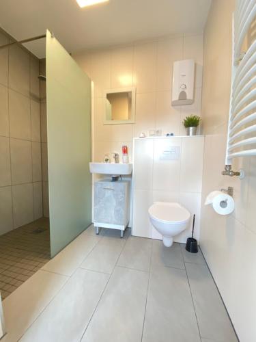 a white bathroom with a toilet and a sink at Schulz Apartments in Bonn