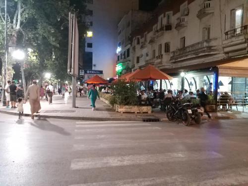 un gruppo di persone che camminano lungo una strada di notte di Ryan 3 a Fes