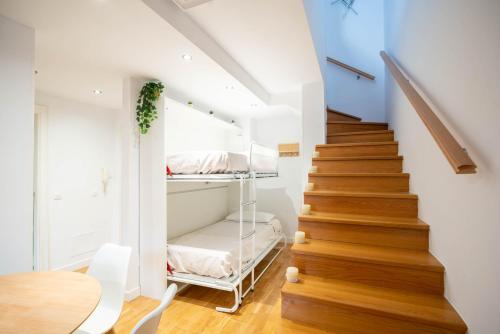 a staircase with a room with a bed and a table at Apartamentos GO - Único Sentido in Tordesillas