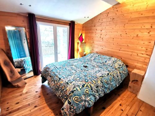 a bedroom with a bed and a wooden wall at La Mélisse 