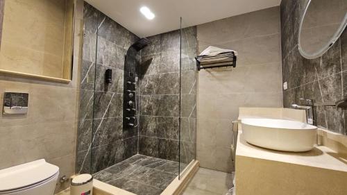 a bathroom with a shower and a sink and a toilet at My Villa Hotel in Sheikh Zayed