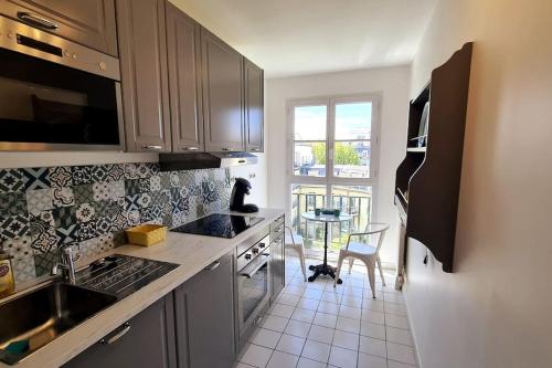une cuisine avec un évier et un plan de travail dans l'établissement Appt 80m², 13 P, Disneyland, Fibre, 2 parkings, à Chessy