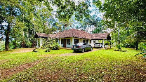 a house with a car parked in front of it at Captain's Bungalow, Kandy in Arawwawala