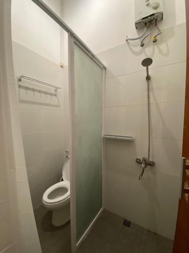 a bathroom with a toilet and a glass shower door at ReVive by Snooze in Banyuwangi