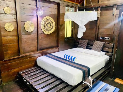 sypialnia z 2 łóżkami w pokoju z drewnianymi ścianami w obiekcie Coco Palm Villa and Cabanas w Tangalli