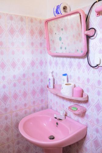 a pink bathroom with a sink and a mirror at Summer Lanka Surf House in Hikkaduwa