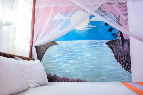 a bedroom with a painting on the wall at Summer Lanka Surf House in Hikkaduwa
