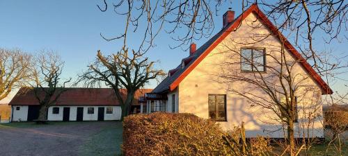 een groot wit huis met een rood dak bij Lantligt och lugnt boende nära natur och stad in Svedala