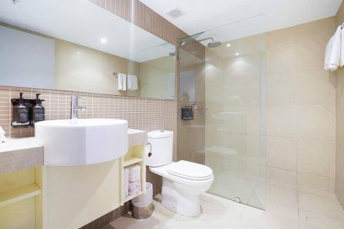 La salle de bains est pourvue de toilettes, d'un lavabo et d'une douche. dans l'établissement Habour & City View Apartment on 11th Floor - King Bed, à Darwin