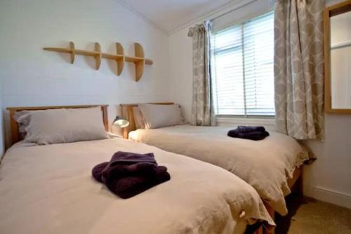 Duas camas sentadas uma ao lado da outra num quarto em Salcombe Retreat Lodge 2 em Soar