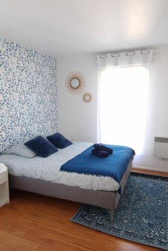 une chambre avec un lit avec des draps bleus et une fenêtre dans l'établissement Le Royal Condo, 13 P, WIFI & Parking à Disneyland, à Chessy