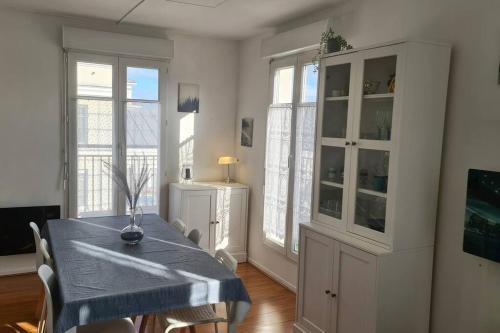a dining room with a blue table and chairs at Le Royal Condo, 13 P, WIFI & Parking à Disneyland in Chessy