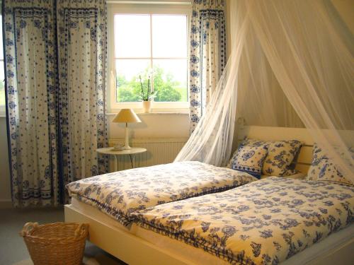 a bedroom with a canopy bed with a window at Ferienidyll Aumühle "Muswiese" in Rot am See