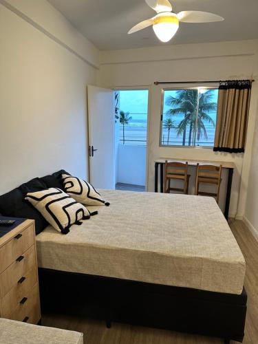 a bedroom with a bed and a view of the ocean at Pé na areia, vista mar, wi-fi e varanda ! in Praia Grande