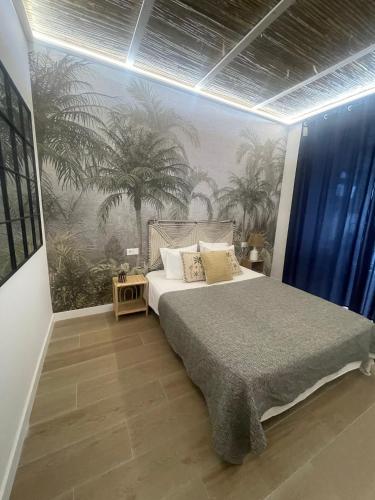 a bedroom with a bed and a mural of palm trees at casa Albufera boutique in Valencia