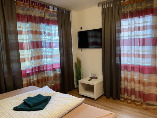 a bedroom with curtains and a bed and a tv at Cochemer Arkaden in Cochem