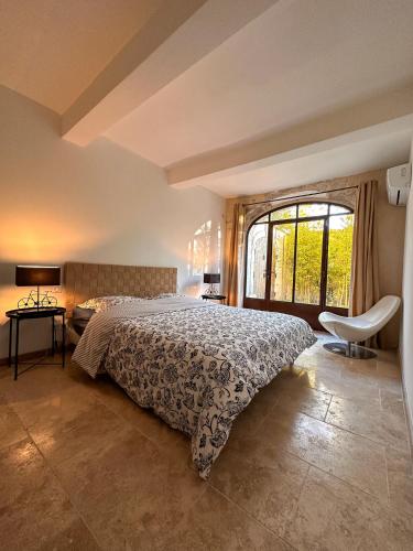 une chambre avec un lit et une grande fenêtre dans l'établissement L'appart des Anges, à Althen-des-Paluds