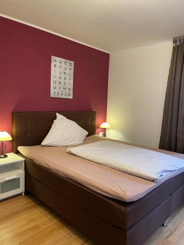uma cama num quarto com uma parede vermelha em Cochemer Arkaden em Cochem