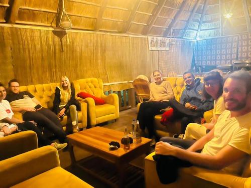 un gruppo di persone seduti sui divani in una stanza di Doublegsafaris and camp mikumi a Mikumi