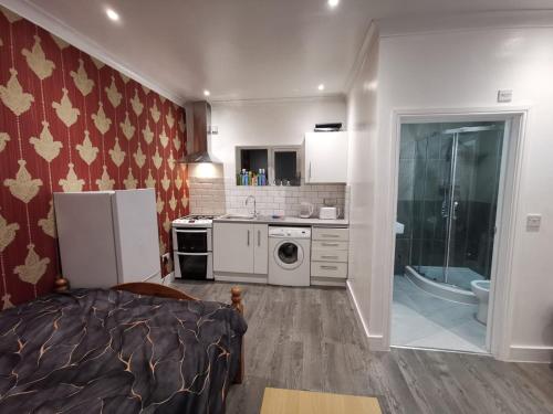 a kitchen with a refrigerator and a sink at Studio Apartment near Luton Airport and Luton Central in Luton