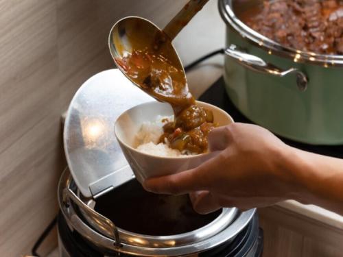 a person holding a bowl of food in a toaster at APA Hotel TKP Sendai Eki Kita in Sendai