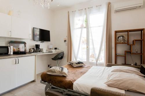 une chambre avec un grand lit et une fenêtre dans l'établissement Mythique Miramar Cannes Croisette Terrasse Clim Parking Wifi, à Cannes