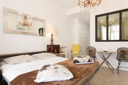 - une chambre avec un lit, une table et des chaises dans l'établissement Mythique Miramar Cannes Croisette Terrasse Clim Parking Wifi, à Cannes