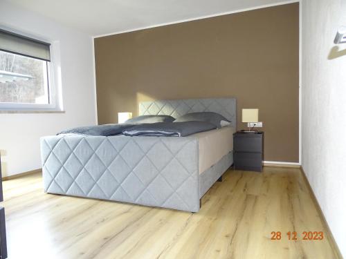 a bedroom with a bed and a wooden floor at Glück auf - Ferienhaus zum Rauchfangkehrer in Wörgl