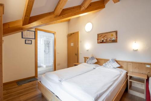 a bedroom with a large white bed in a room at Villa Adria B&B in Canazei