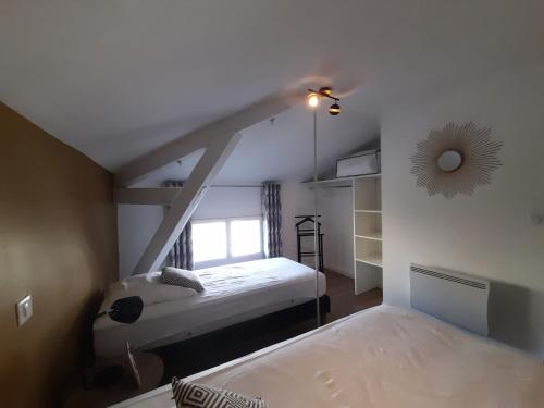 - une chambre mansardée avec 2 lits et une fenêtre dans l'établissement Léon, à Dax