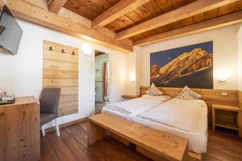 a bedroom with a large bed and a wooden ceiling at Villa Adria B&B in Canazei