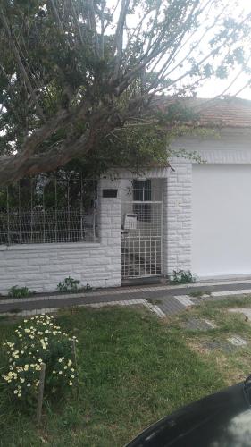 una casa blanca con una puerta y un garaje en Casa 2 ambientes Mar del Plata en Mar del Plata