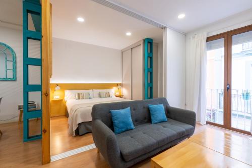 a living room with a couch and a bed at Locksmith Apartment -Wifi- Park Option in Seville