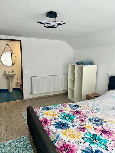 a bedroom with a bed with a floral bedspread at Casa Vera in Vidra