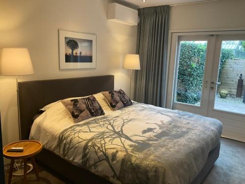 a bedroom with a bed with two pillows and a window at African Tree in Terwolde