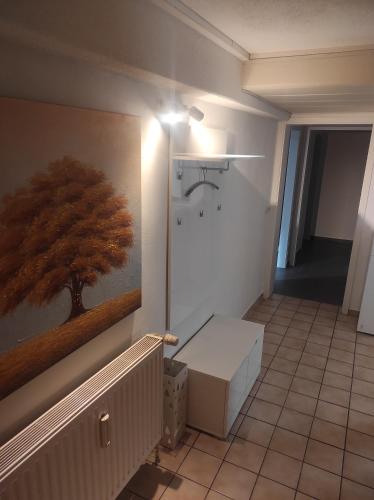 a hallway with a painting of a tree on the wall at Ferienwohnung Neubrandenburg-Broda - Ruhe und mehr in Neubrandenburg