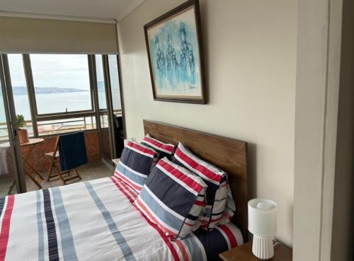 1 dormitorio con 1 cama y vistas al océano en Departamento en el corazón de Reñaca en Viña del Mar