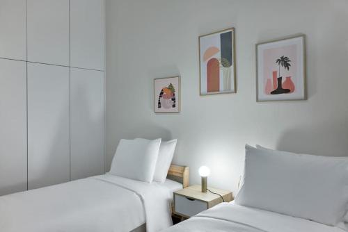 2 camas en una habitación con paredes blancas en Quiet, central 2bd Apt, Kolonaki, en Atenas